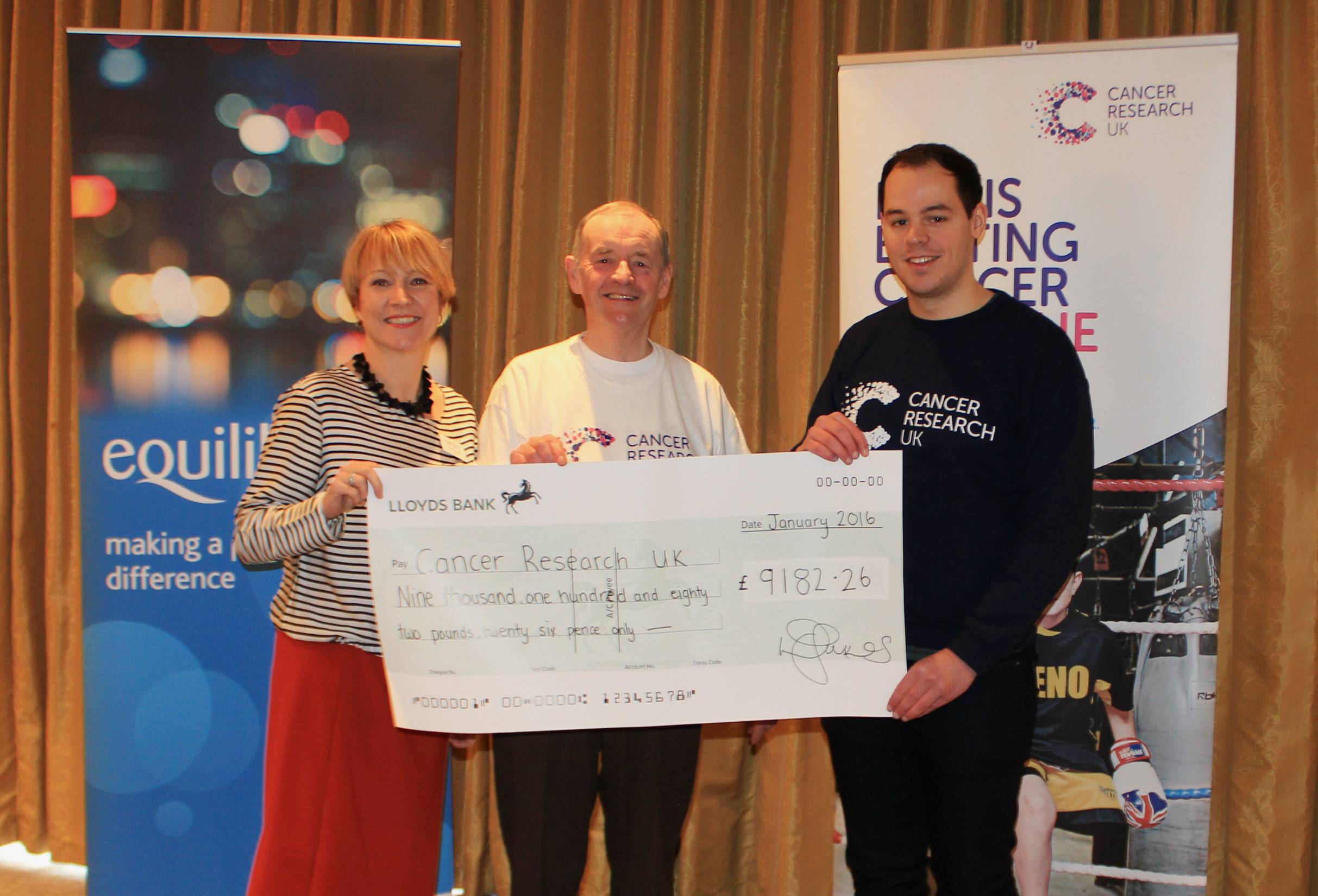 Cancer Research representatives receiving a large cheque from equilibrium for over £9,000