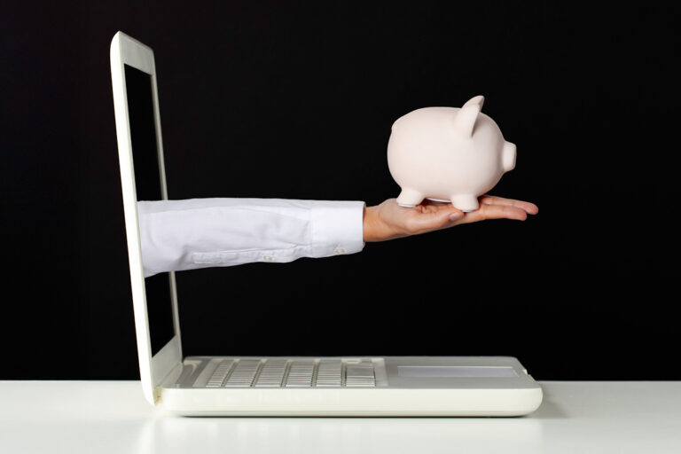 laptop with arm coming out which is holding a piggy bank